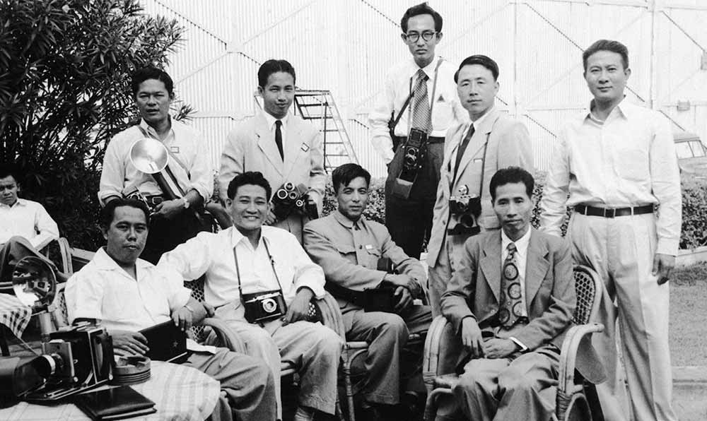 新華社記者錢嗣杰（站立者右二）在采訪會議開幕式后和外國記者在會場外休息。