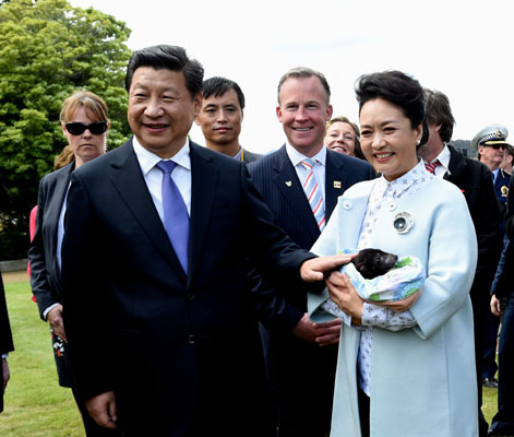 11月18日，國(guó)家主席習(xí)近平在澳大利亞塔斯馬尼亞州與朗塞斯頓市斯科奇－歐克伯恩小學(xué)的小學(xué)生共同植樹(shù)。這是習(xí)近平和夫人彭麗媛植樹(shù)后撫摸袋獾。新華社記者 饒愛(ài)民 攝